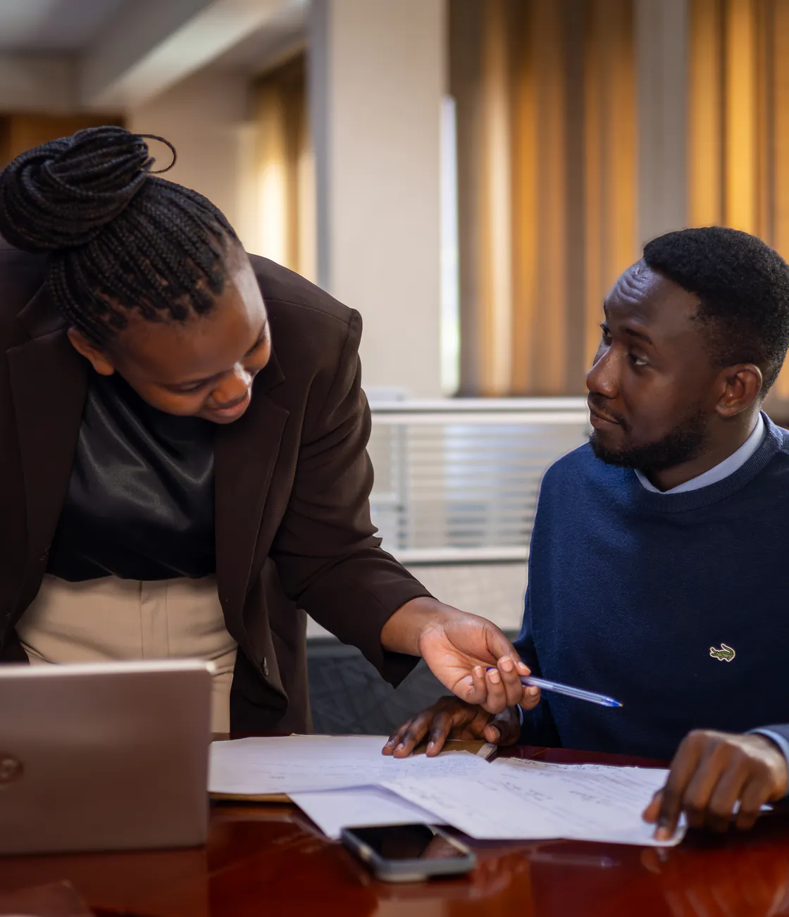 Two Kisaka colleagues talking through a written plan at the meeting table